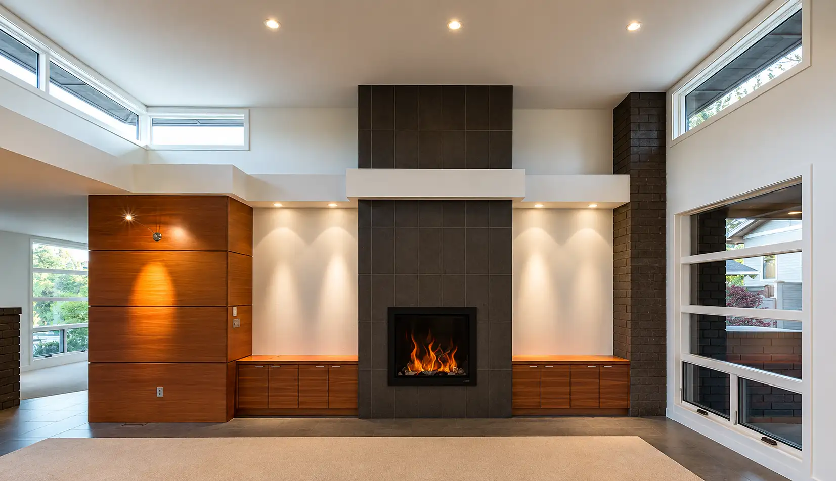 Great room with floor-to-ceiling tiled fireplace, lit hearth and custom wood built-ins